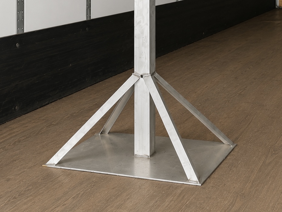 The TRSS 30 by 30 inch aluminum base plate with welded gussets, standing on a trailer floor